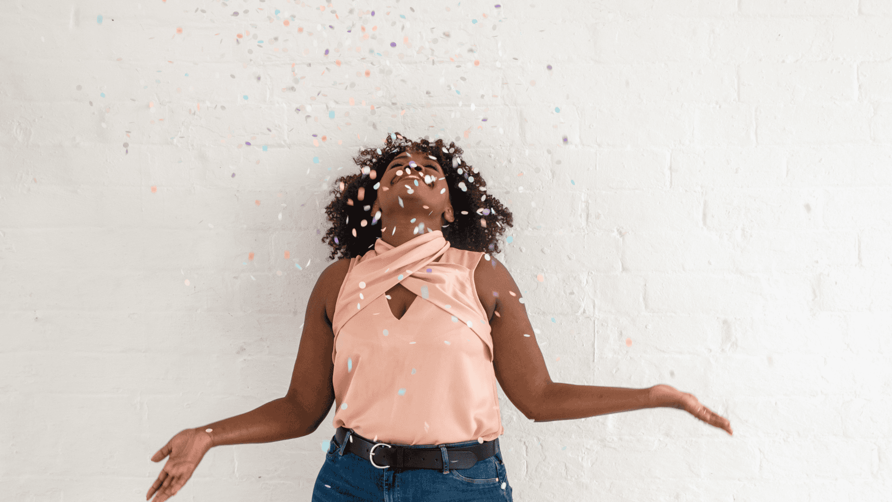 Woman celebrating with confetti, expressing joy and positivity.