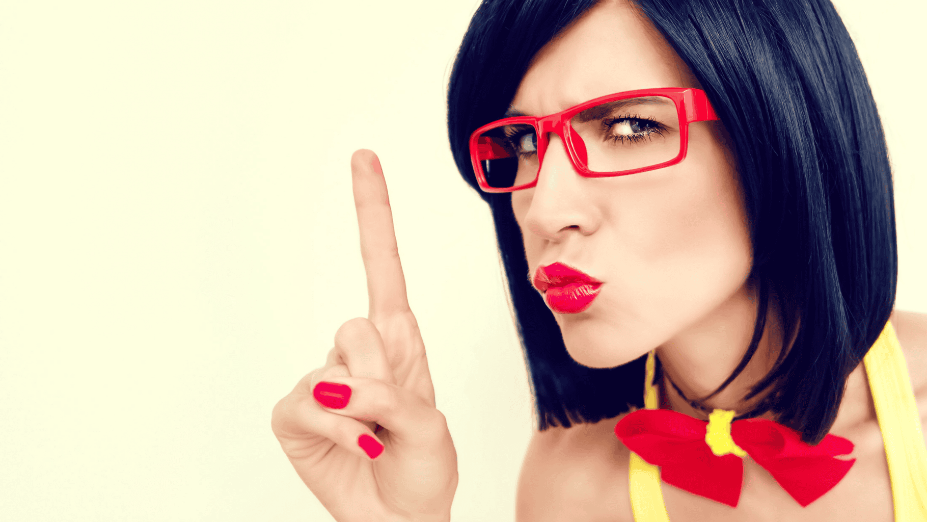 Woman with black hair and red glasses making a 'no' gesture.