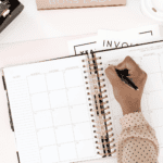 Person writing in a planner with marriage notes and stationery around.