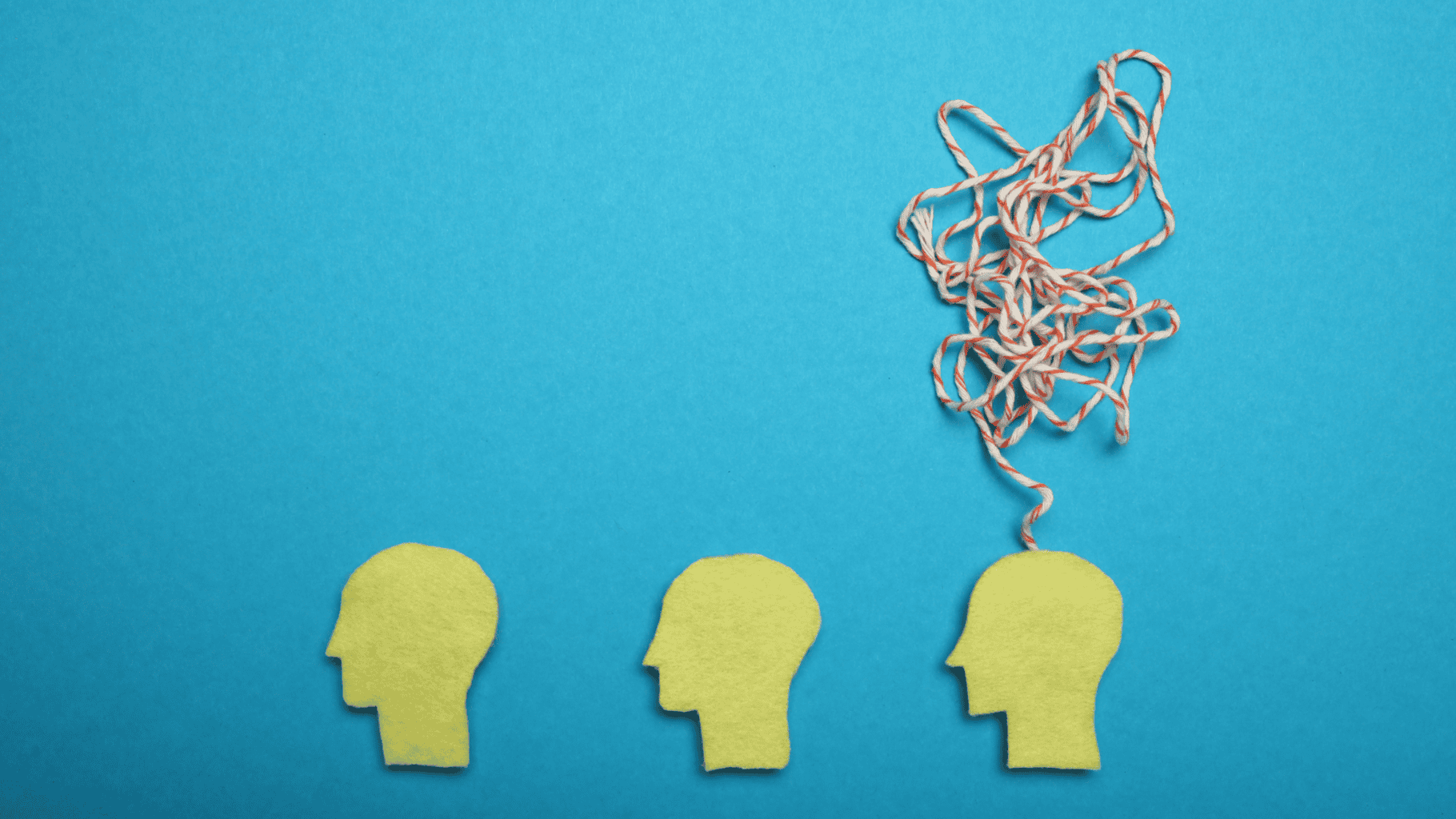 Tangled string emerging from a head-shaped cutout symbolising confusion or overthinking.